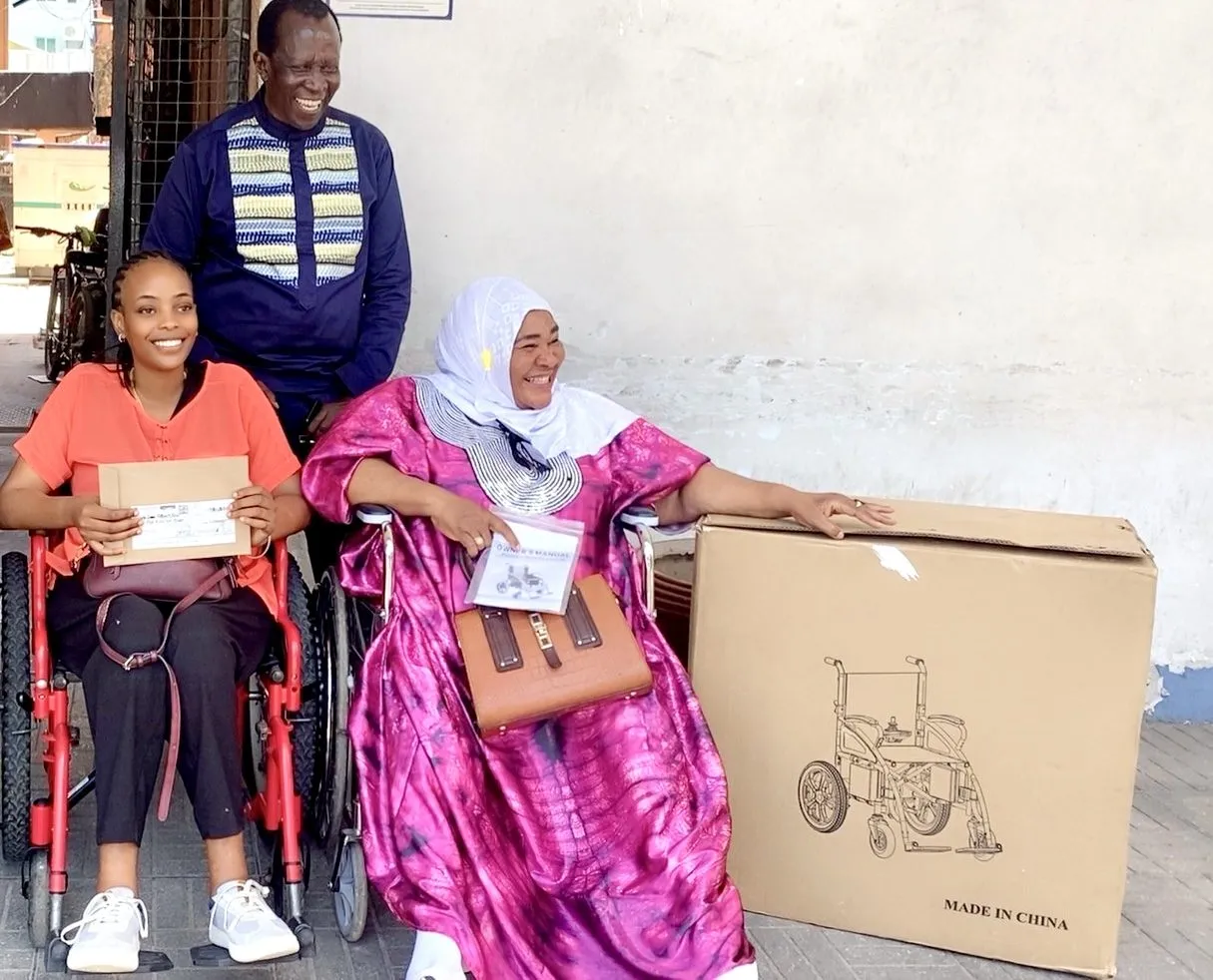 Tupo Sawa donates an electric wheelchair to Bi. Mwanaidi